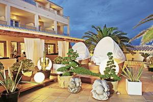 Außenbereich des Tahiti Hotels mit stilvollen Pflanzen, beleuchteten Kugeln und Lounge-Möbeln.