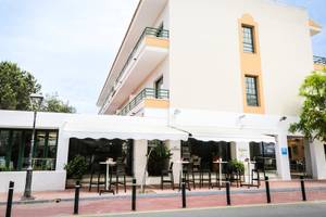 Außenansicht des Rosales Formentera Hotels mit Terrasse und Tischen.