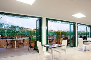 Innenbereich des Restaurants des Rosales Formentera Hotels mit Tischen, Stühlen und Pflanzen.