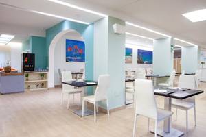 Innenansicht des Restaurants im Hotel Rosales Formentera mit blauen Wänden und weißen Möbeln.