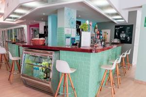 Rezept Theke im Rosales Formentera Hotel mit grünen Wänden und weißen Stühlen.