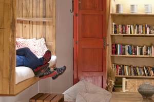Ein Bett und ein Bücherregal im Castavi Hotel.
