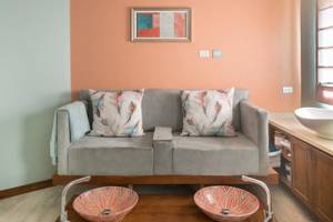 Ein Wohnzimmer mit einem grauen Sofa und zwei dekorativen Waschbecken auf einem Tisch.