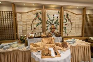 Buffet-Tisch mit Brot im Eliros Mare Hotel, geschmückt mit bunten Glasmalereien.