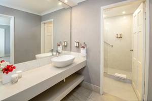 Badezimmer im Sugar Bay Barbados Hotel mit großem Spiegel und Glasdusche.