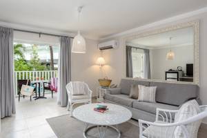 Wohnzimmer von Sugar Bay Barbados mit Sofa, Tisch, Stühlen und Spiegel
