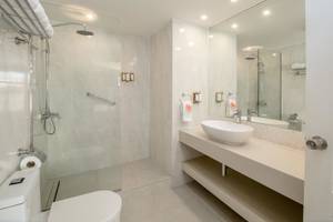 Badezimmer im Sugar Bay Barbados Hotel mit Glasdusche, Waschbecken und Toilette.