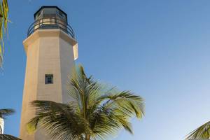 Leuchtturm des Hilton Barbados Hotels mit blauem Himmel und Palmen im Vordergrund