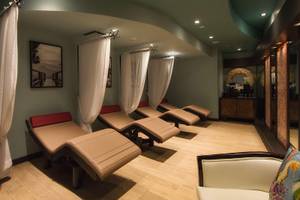Spa-Lounge-Bereich im Hilton Barbados mit mehreren Behandlungsliegen und weißen Vorhängen.