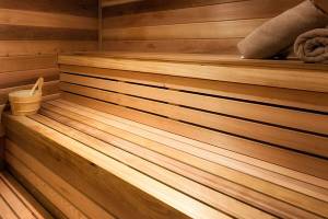 Sauna im Hilton Barbados mit Holzwänden und -bänken sowie einem Holzeimer