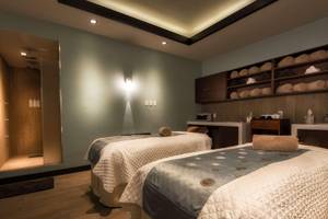 Spa-Massageraum im Hilton Barbados mit zwei Betten und Einrichtungen.