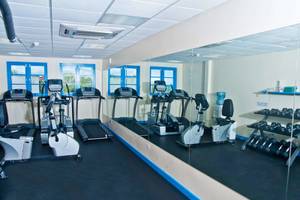 Fitnessbereich des Rostrevor Hotels mit Laufbändern, Spinrädern und Hanteln.