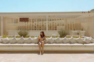 Frau in Bikini sitzt vor der Bar im Sunrise Anjum Resort
