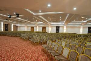Großer Konferenzsaal im Alan Xafira Deluxe Resort & Spa, mit vielen Reihen von Stühlen und rotem Teppich.