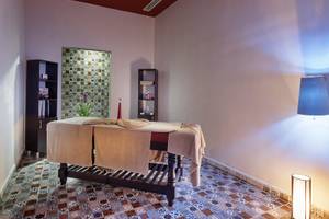 Massageraum im Alan Xafira Deluxe Resort & Spa mit Tisch, Kerzen und dekorativen Wandfliesen.