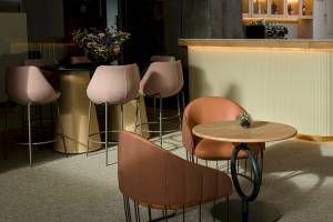 Innenansicht der Bar im Plus Fariones Suite Hotel mit Barhockern und Tischen.