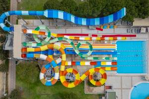 Luftaufnahme des Wasserparks im Ducale Lara Hotel mit mehreren Wasserrutschen und einem großen Pool.