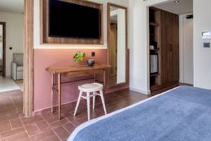 Innenansicht eines Zimmers im Domes Aulus Zante Hotel mit einem Bett, Schreibtisch und Fernseher