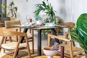 Restaurantbereich des Domes Aulus Zante Hotels mit gedecktem Tisch und Holzmöbeln.