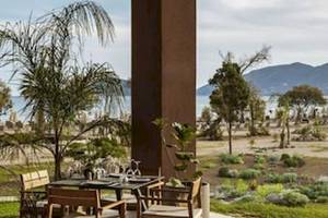 Außenbereich des Domes Aulus Zante Hotels mit Tisch und Blick auf das Meer.