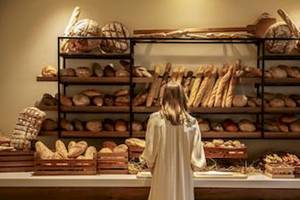 Frau vor einer Auswahl von Brotsorten im Hotel Domes Aulus Zante.