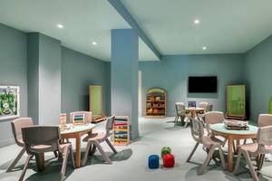 Kinder Spielzimmer im Domes Aulus Zante mit bunten Wänden, Tischen, Stühlen und Spielzeug.