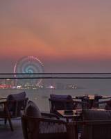 Abendliche Terrasse des W Dubai - Mina Seyahi mit Blick auf eine Stadt und ein Riesenrad