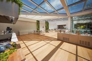 Innenbereich des VOI Marsa Siclà Essentia Hotels mit Glasdach und Holzboden.