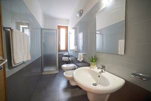 Ein Badezimmer mit einer Dusche, Toilette, Waschbecken und Handtüchern.