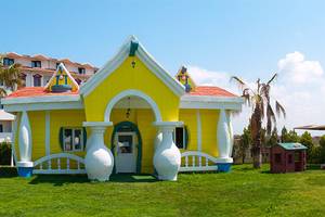 Gelbes charakteristisches Haus im Garten des Cesars Side Hotels
