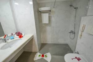 Badezimmer im Cesars Side Hotel mit Dusche, Waschbecken und Toilette.