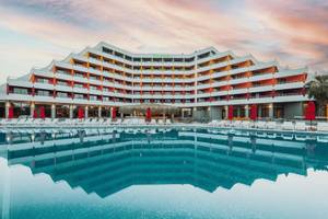 Außenansicht des Megasaray Resort Side mit Pool und Sonnenliegen.