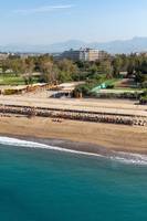 Luftaufnahme des Megasaray Resort Side Strand mit Liegen und Gebäuden im Hintergrund.