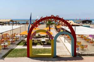 Außenbereich des Megasaray Resort Side mit bunten Eingangsbogen und Strandliegen