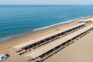Luftaufnahme des Megasaray Resort Strands mit vielen Liegen unter Sonnenschirmen