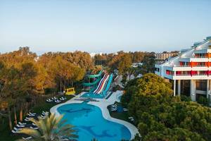 Luftaufnahme des Megasaray Resort Side mit Pool und Wasserrutschen, umgeben von Bäumen und Liegestühlen.