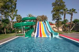 Wasserrutschen im Megasaray Resort Side mit grünen und bunten Rutschen neben einem Pool.