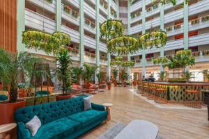 Lobby des Megasaray Resort Side Hotels mit blauem Sofa, grünen Pflanzen und Holzboden.
