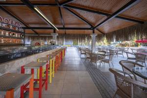 Innenansicht der Bar des Megasaray Resort Side mit Thekenhockern, Tischen und Stühlen.