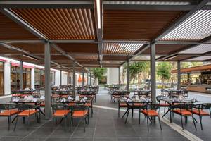 Außenbereich des Megasaray Resort Side mit mehreren Tischen und Stühlen unter einem Dach.