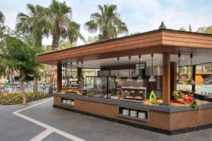 Außenbüfett im Megasaray Resort Side mit Essensausgabe, umgeben von Palmen und Tischplätzen.