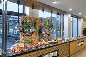 Buffet-Tisch im Megasaray Resort Side mit verschiedenen Speisen und Blick auf den Garten.