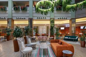 Lobby des Megasaray Resort Side Hotels mit Pflanzen, Sofas und Tischen.