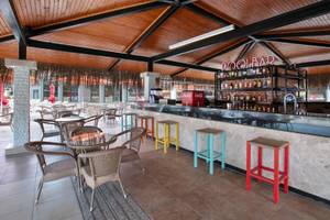 Innenansicht der Poolbar des Megasaray Resort Side mit Holzdecke, Bartheken und bunten Hockern.