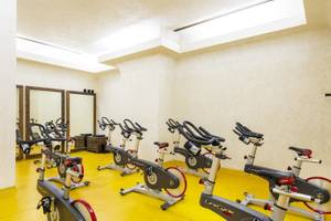Fitnessstudio im Sharq Village und Spa mit mehreren Spinrädern und Spiegeln