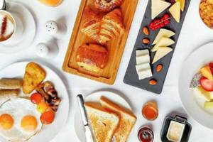 Frühstücksbuffet im Al Najada Doha Hotel by Tivoli mit verschiedenen Speisen und Getränken.
