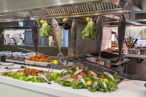 Fischbuffet im Royal Taj Mahal Hotel mit verschiedenen Fischarten und Salat.
