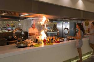 Chef brät Gerichte am offenen Feuer im Royal Taj Mahal Hotel.