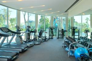 Fitnessstudio im Banana Island Resort Doha mit Laufbändern und Hanteln.