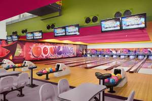 Bowlinghalle im Banana Island Resort Doha von Anantara mit bunten Bowlingbahnen und Bildschirmen